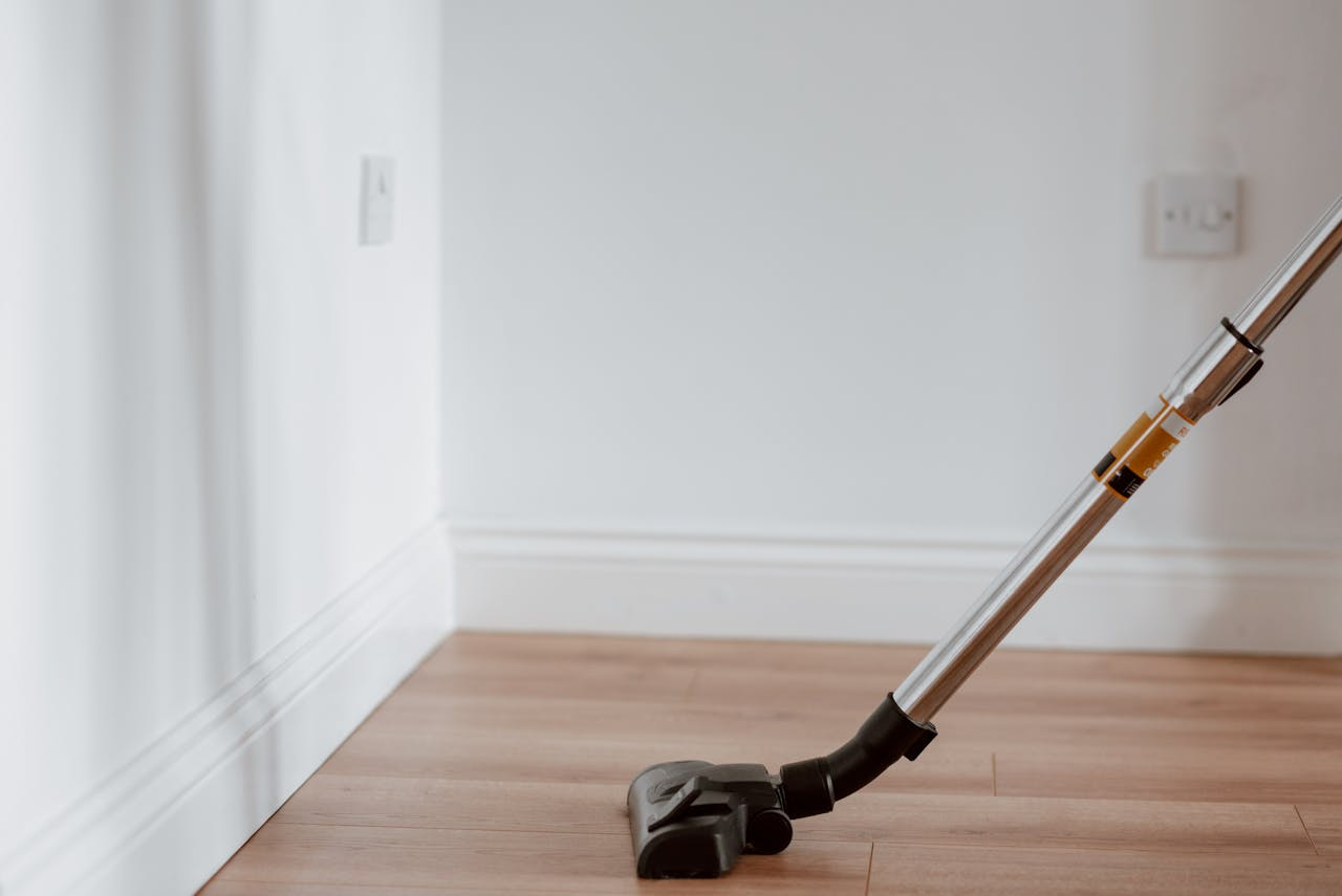Electrical apparatus collecting dust on wooden parquet in empty room of apartment in daylight