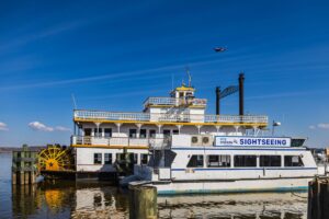 A scenic cruise boat docked at Alexandria waterfront under a clear blue sky.